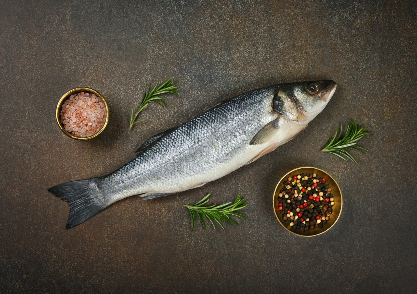 Raw European sea bass fish on table